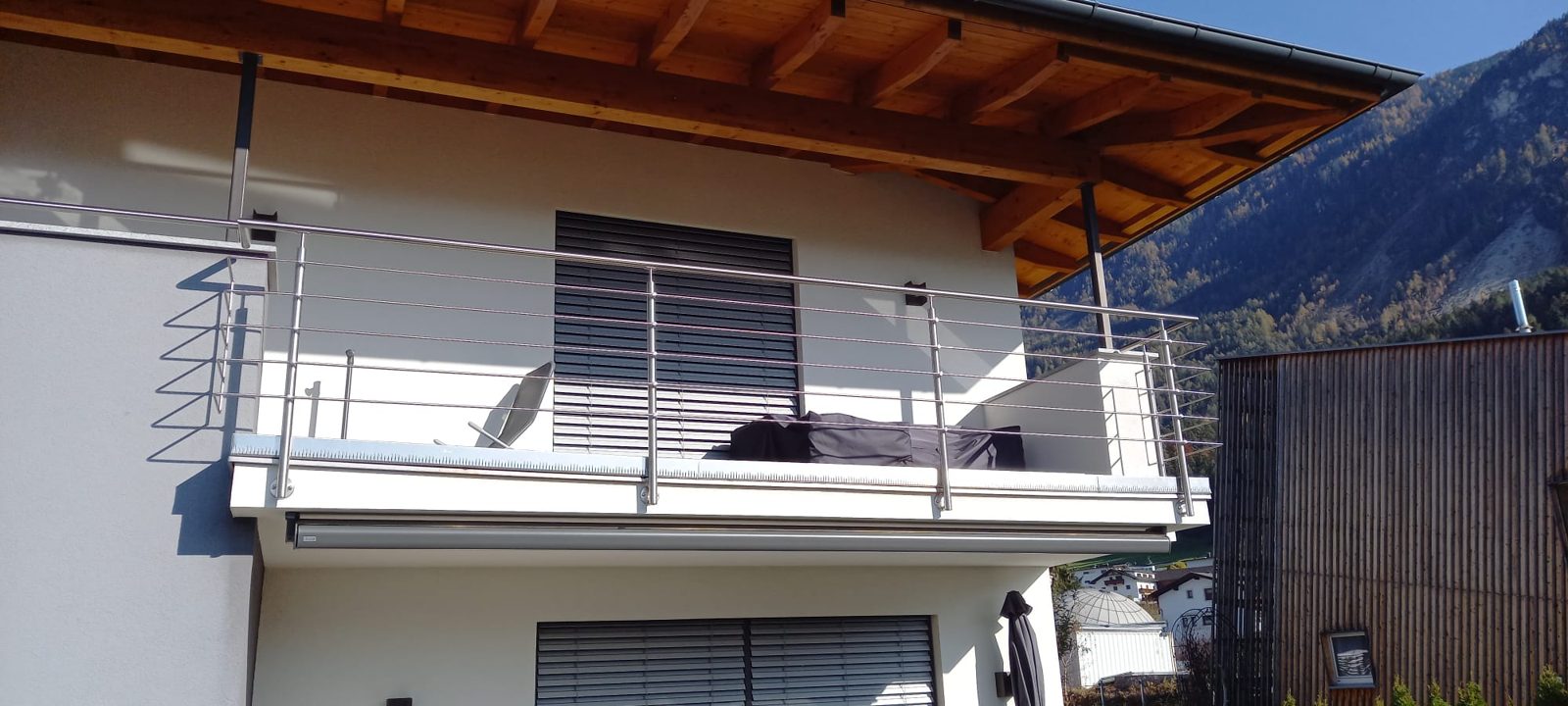 Edelstahlgeländer an einem Balkon mit Holzdach
