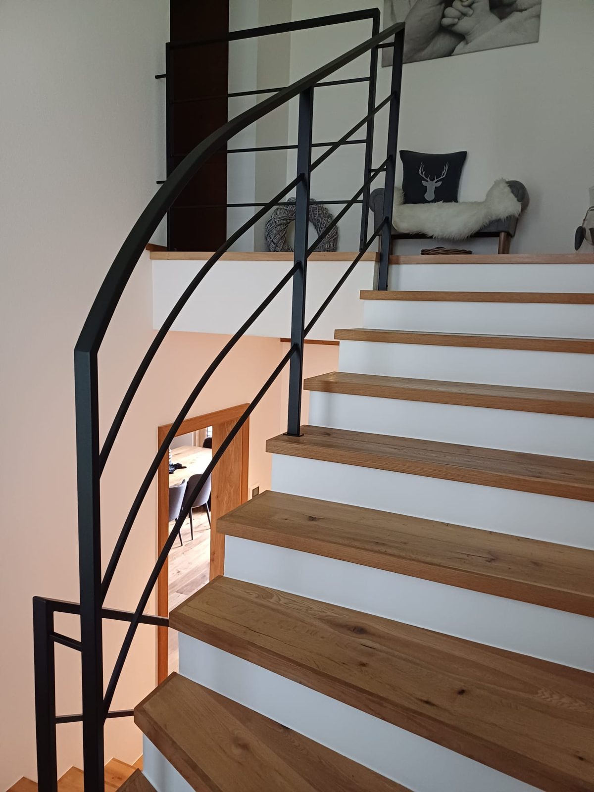 Modernes schwarzes Stahlgeländer entlang einer Holztreppe