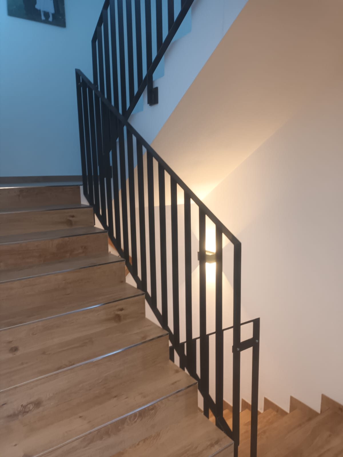 Schlichtes Stabgeländer aus Stahl an einer Holztreppe