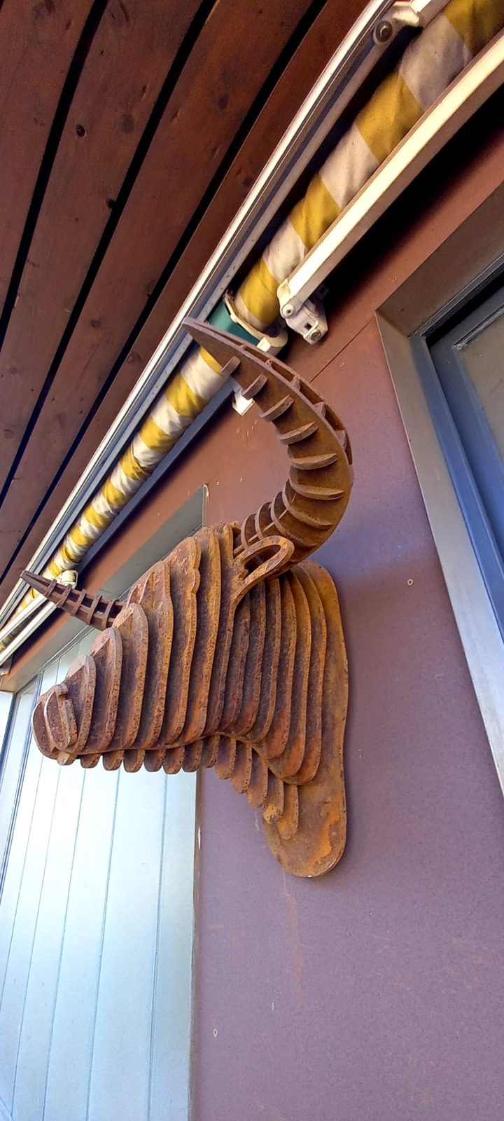 Hirschkopf aus Cortenstahl als Wandobjekt an einer Fassade