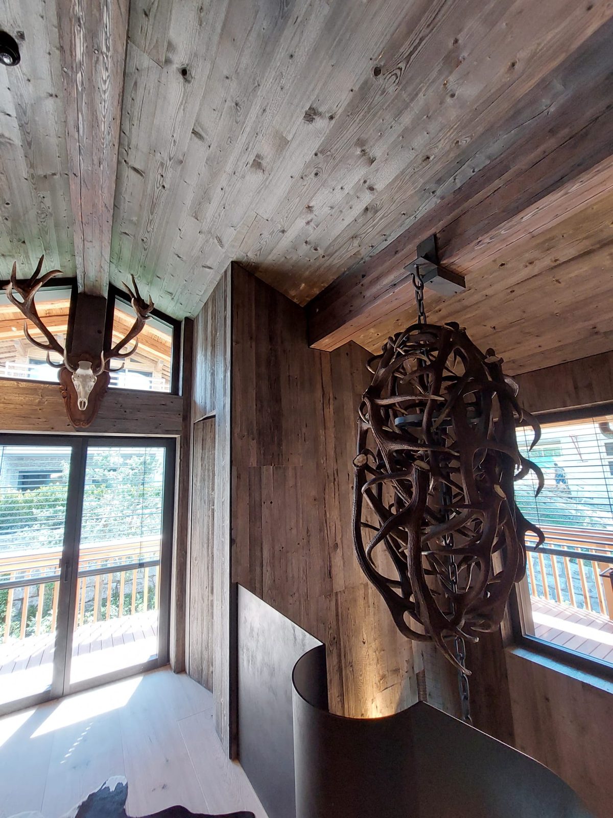 Luster aus Hirschgeweihen in einem Chalet mit Altholz