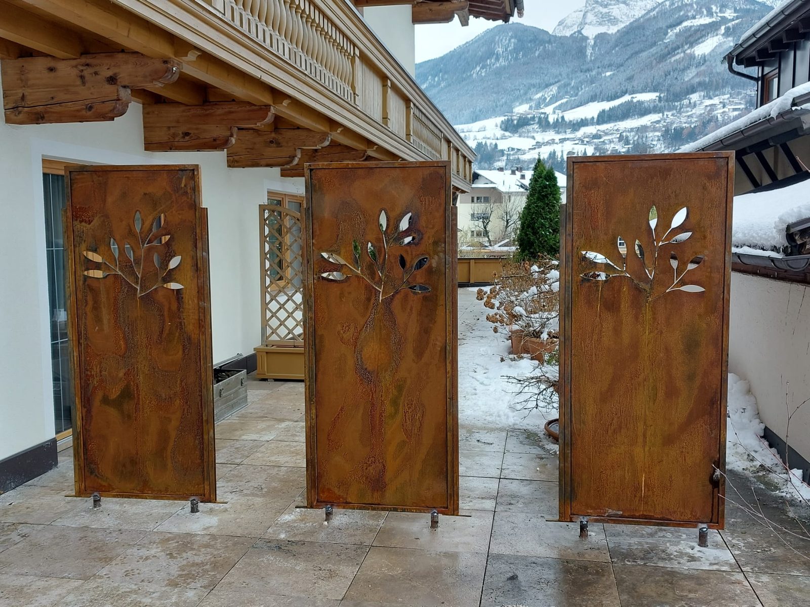 Sichtschutzwände aus Cortenstahl mit Baummotiv auf einer Terrasse