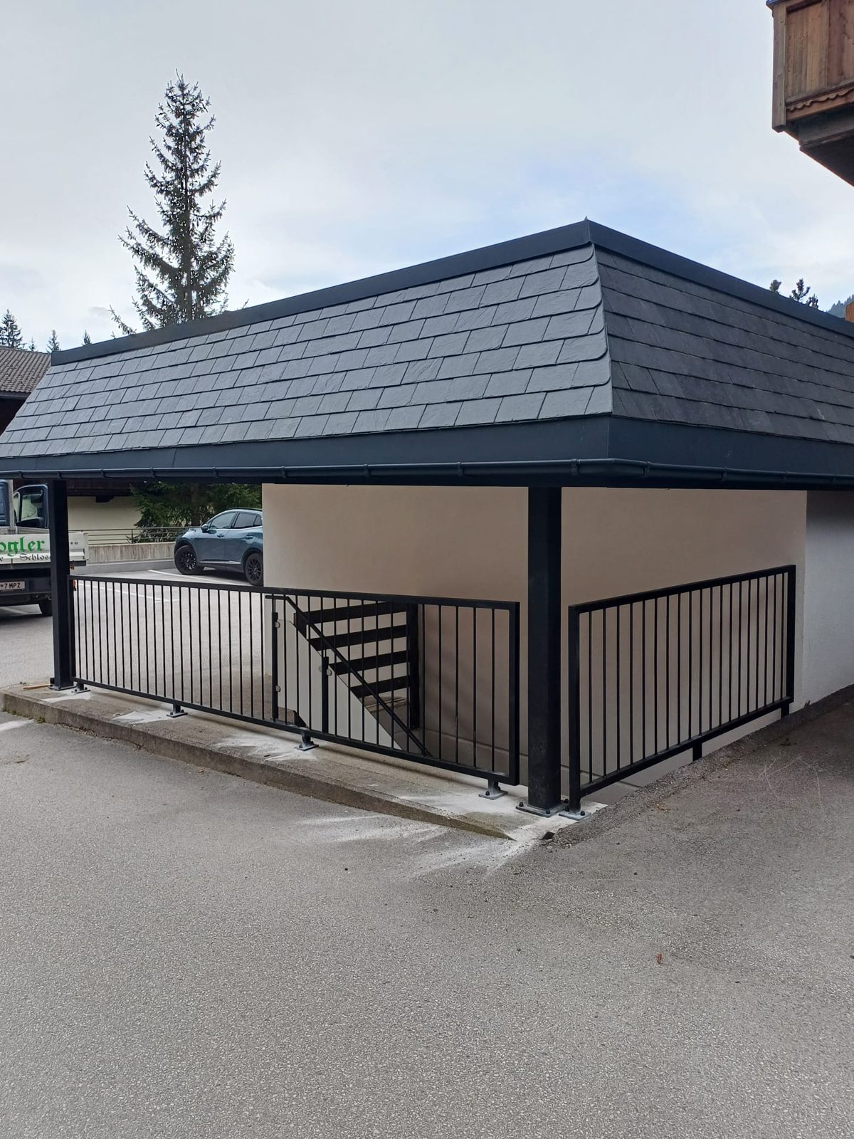 Schwarzer Stabzaun mit Gehtüre an einem Carport